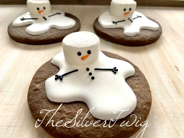 Snowman decorated cookies on wood surface